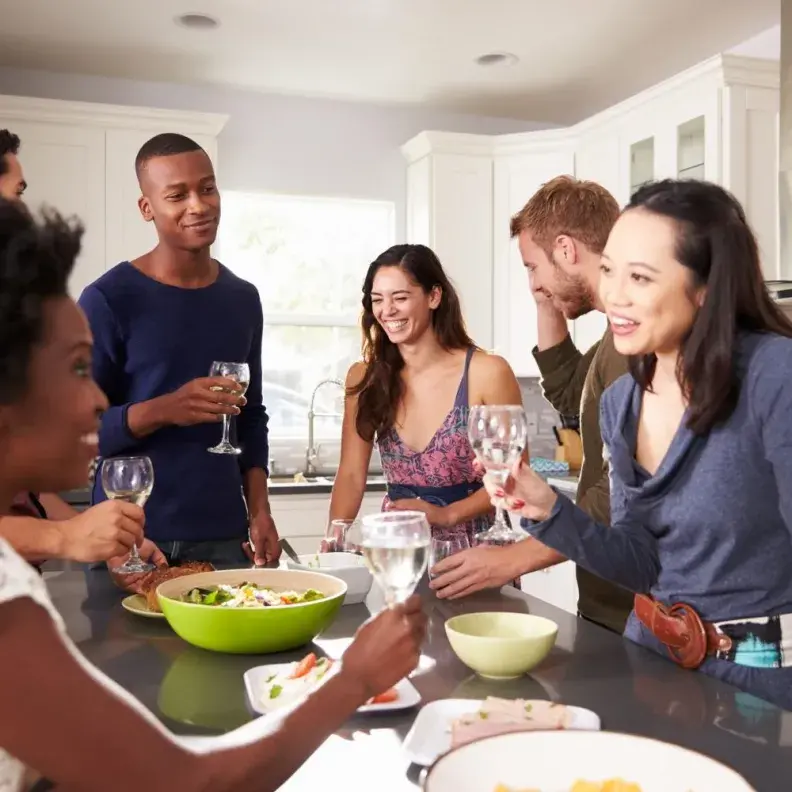 Image: gathering of people with around around kitchen island. Title: Throwing a Fair Trade Party